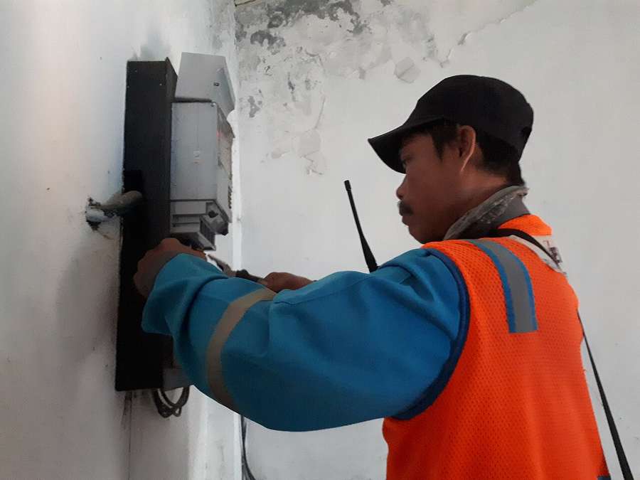 An electrician working on an electricity meter