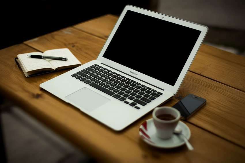 A laptop and notebook on a home office desk