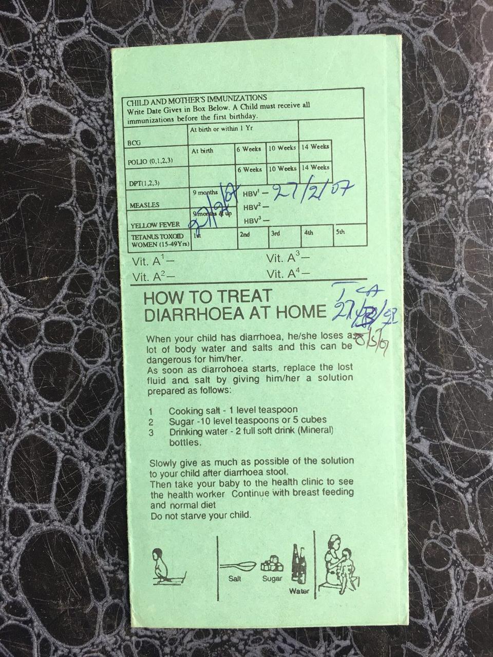 A child's immunisation chart held by a mother