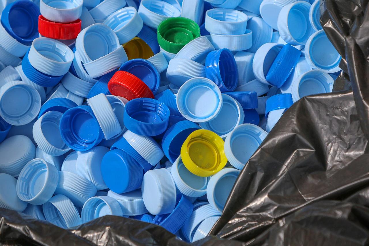 A pile of blue, white, red and green plastic bottle caps